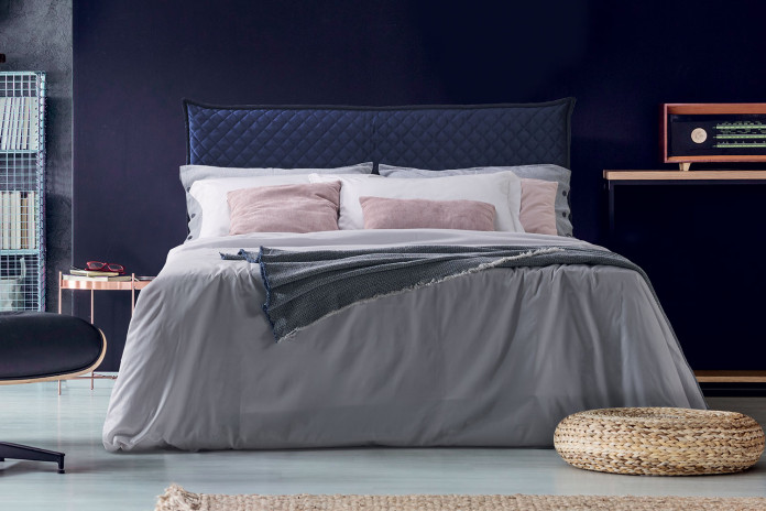 Upholstered double bed with quilted frame and headboard in a square pattern