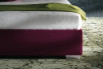 Detail of the thin bed frame with chromed metal feet